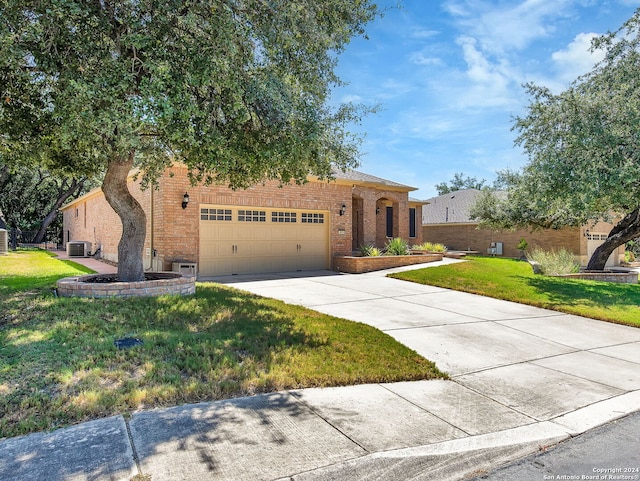 view of front facade with a garage, central air condition unit, and a front yard