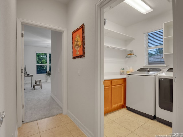 clothes washing area with light tile patterned floors and separate washer and dryer