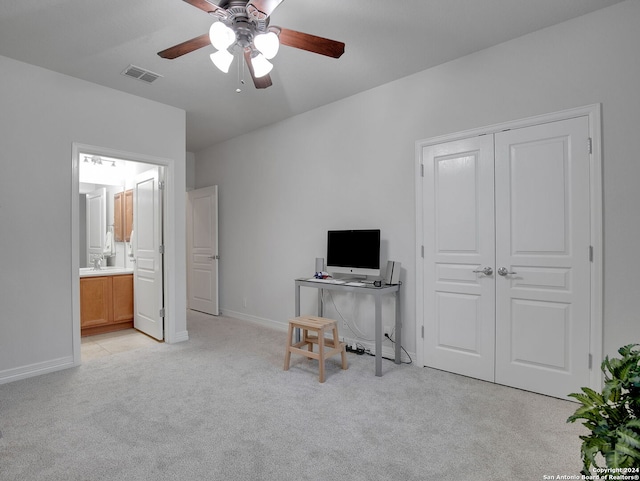 unfurnished office featuring ceiling fan and light colored carpet