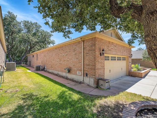 view of home's exterior featuring a garage, central air condition unit, and a yard