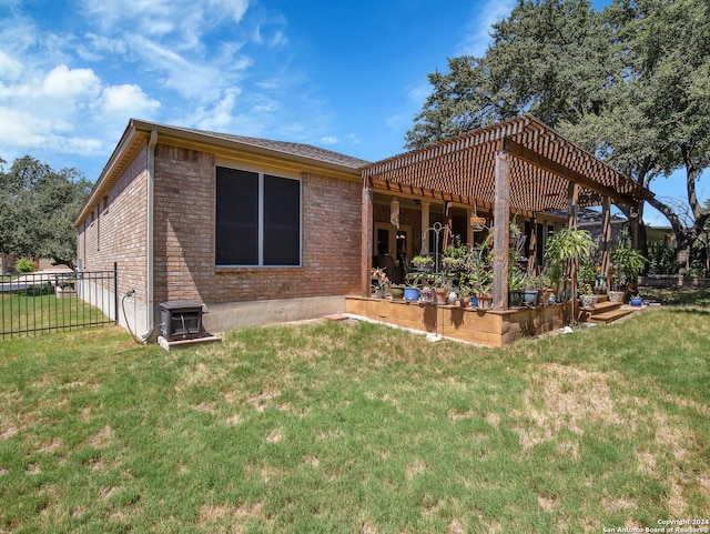 rear view of property with a yard and a pergola