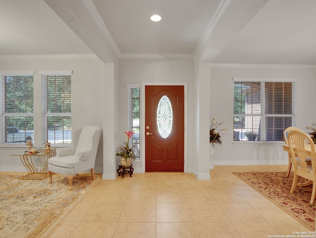 foyer with crown molding, a healthy amount of sunlight, and light tile patterned floors