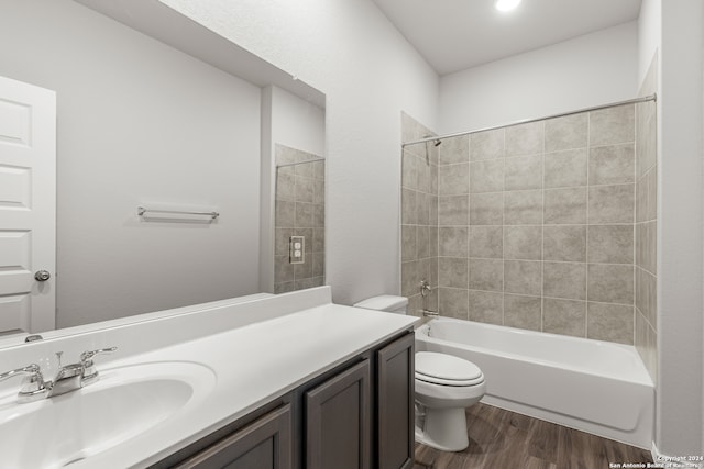 full bathroom featuring toilet, tiled shower / bath combo, vanity, and wood-type flooring