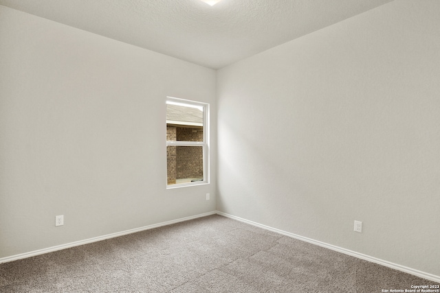 carpeted empty room with a textured ceiling