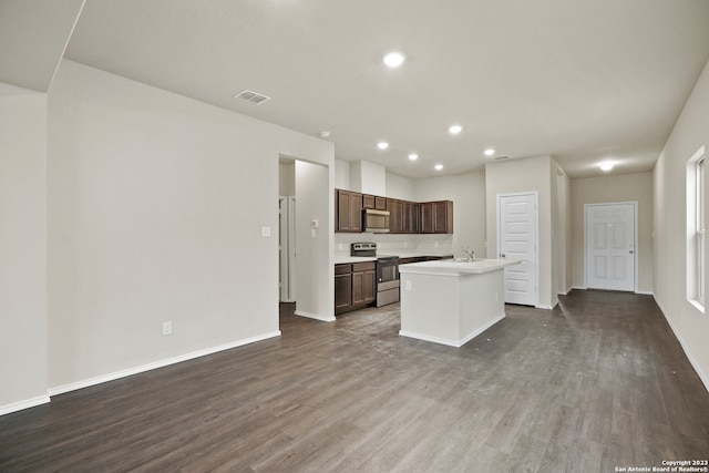 kitchen featuring hardwood / wood-style flooring, a center island with sink, dark brown cabinetry, and stainless steel appliances