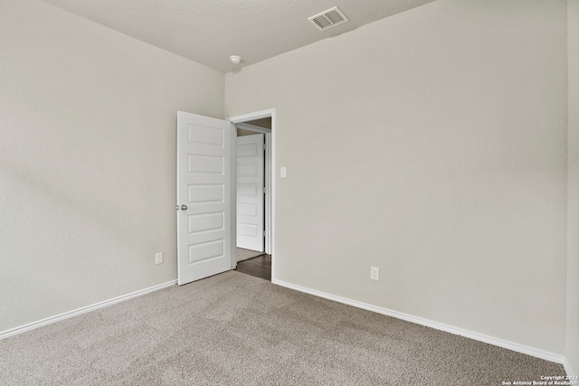 unfurnished room with a textured ceiling and carpet floors