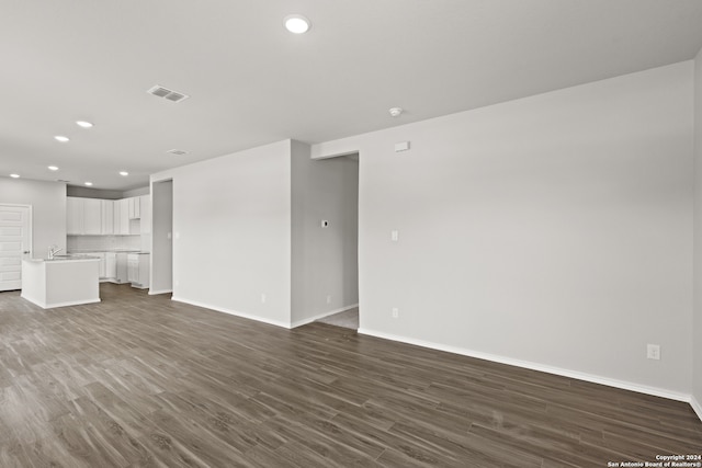 unfurnished living room featuring sink and hardwood / wood-style floors