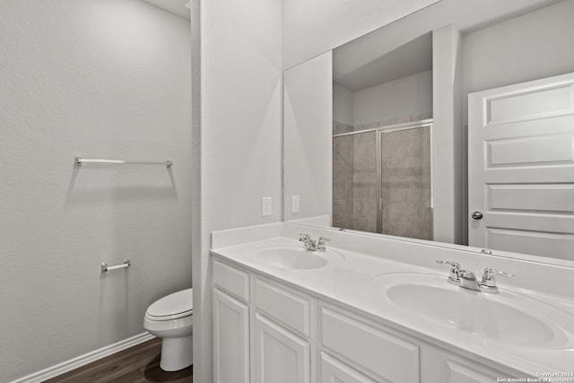 bathroom featuring toilet, double sink vanity, and wood-type flooring