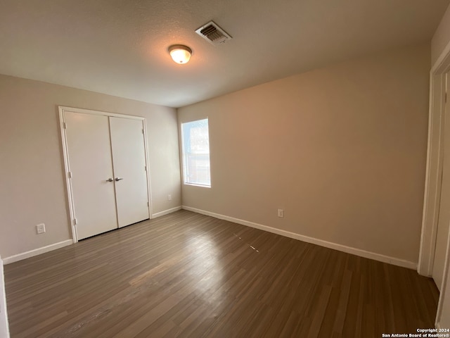 unfurnished bedroom featuring hardwood / wood-style floors and a closet