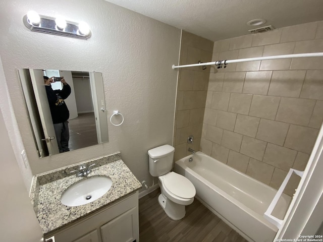 full bathroom with visible vents, toilet, wood finished floors, washtub / shower combination, and vanity