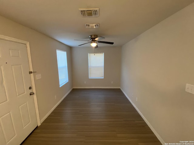 foyer entrance with visible vents, baseboards, dark wood finished floors, and a ceiling fan