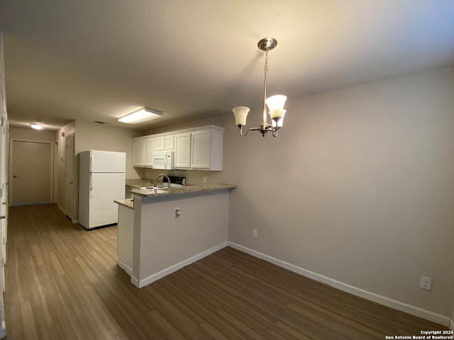 kitchen with hardwood / wood-style floors, white cabinets, kitchen peninsula, an inviting chandelier, and white appliances