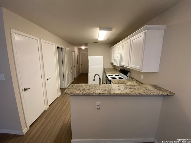 kitchen featuring kitchen peninsula, dark wood-type flooring, and white appliances