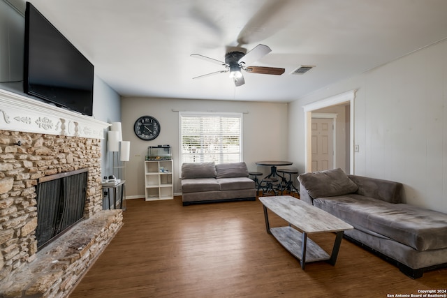 living room featuring ceiling fan, dark hardwood / wood-style flooring, and a fireplace