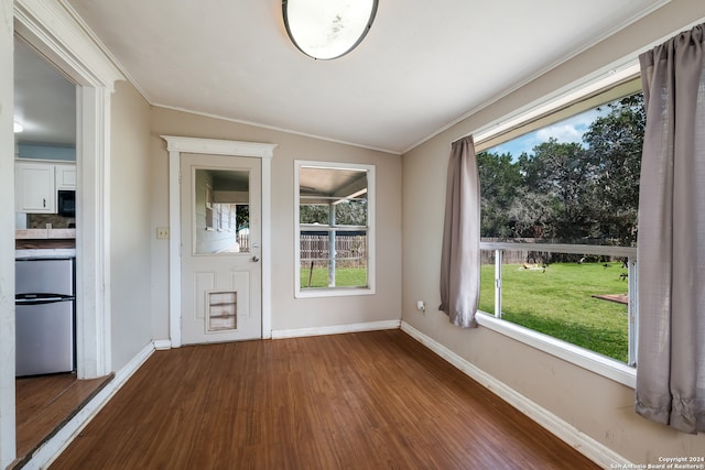 foyer entrance featuring vaulted ceiling, crown molding, and dark wood-type flooring