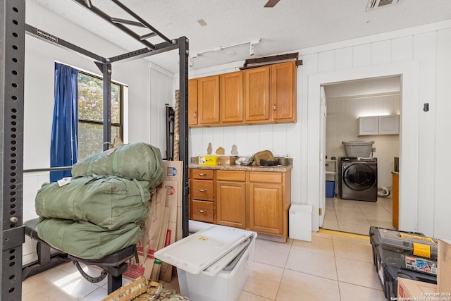 kitchen with washer / clothes dryer, a textured ceiling, and light tile patterned floors