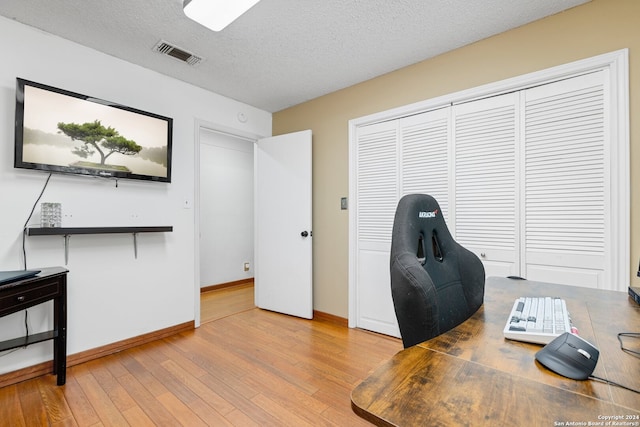 office space featuring a textured ceiling and light hardwood / wood-style floors