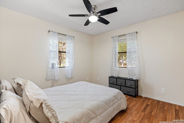 bedroom featuring hardwood / wood-style flooring, a textured ceiling, and ceiling fan