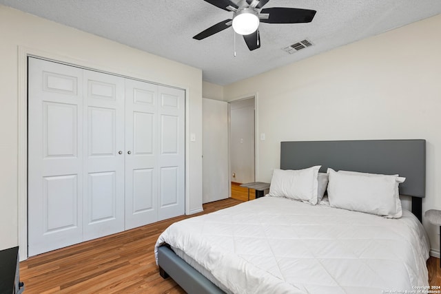 bedroom featuring a textured ceiling, a closet, ceiling fan, and hardwood / wood-style flooring