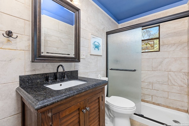 bathroom featuring toilet, an enclosed shower, vanity, and tile walls