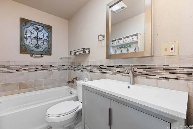 bathroom with tile walls, toilet, vanity, and a tub to relax in