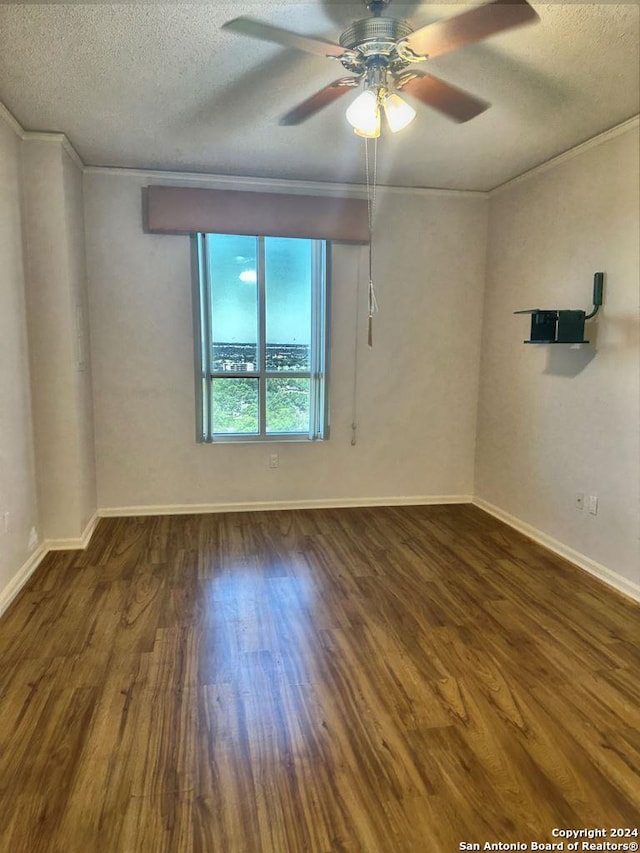 spare room featuring a textured ceiling, ceiling fan, ornamental molding, and wood-type flooring