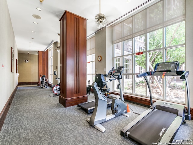 gym with a wealth of natural light, carpet floors, and ceiling fan