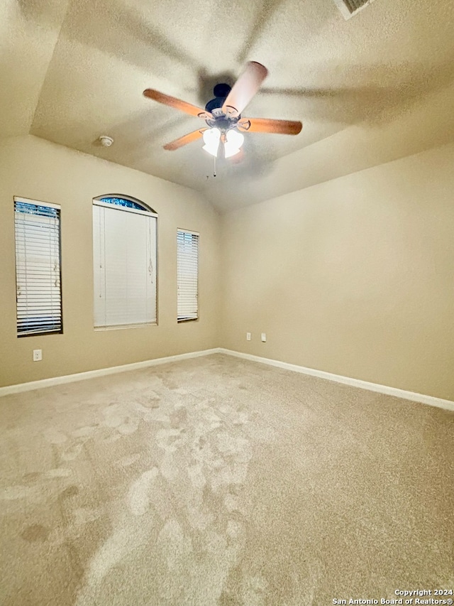 spare room featuring ceiling fan, carpet, a textured ceiling, and lofted ceiling