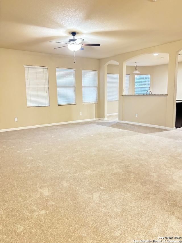 carpeted spare room with ceiling fan