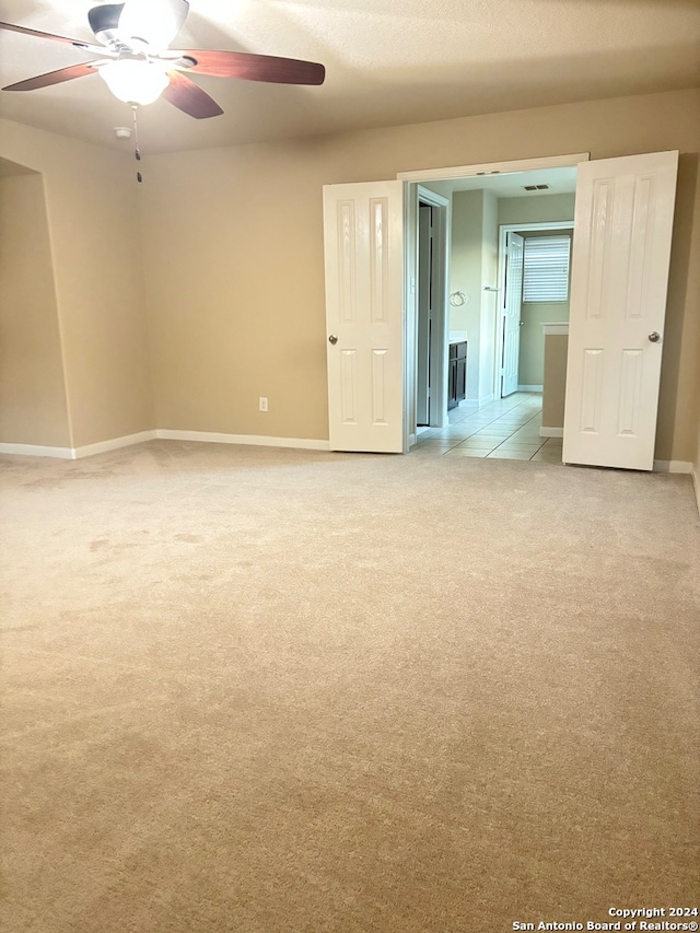 spare room with ceiling fan and light colored carpet