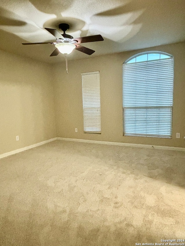 carpeted empty room featuring ceiling fan