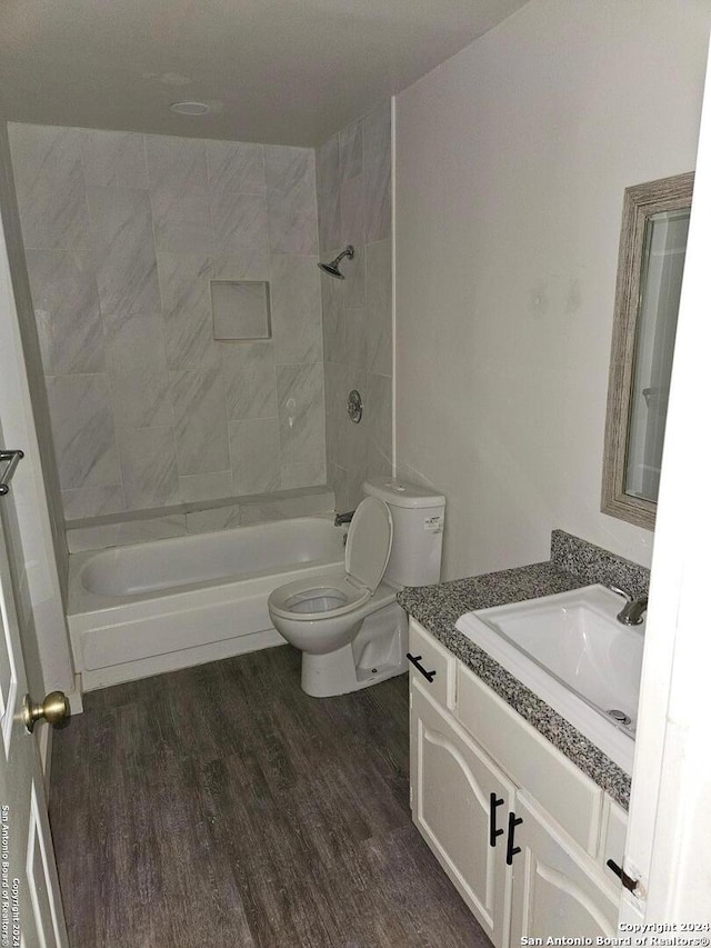 full bathroom with toilet, tiled shower / bath combo, vanity, and wood-type flooring