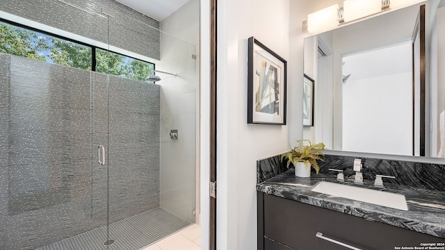 bathroom featuring a shower with door and vanity