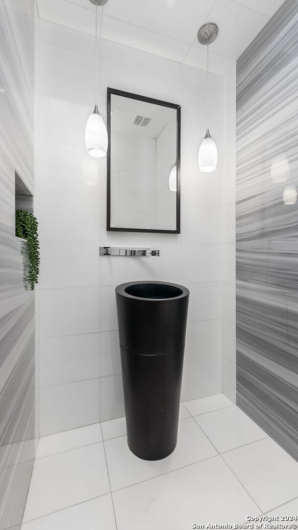 bathroom featuring tile patterned flooring and tile walls