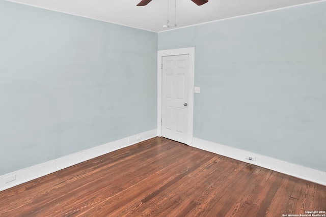 unfurnished room featuring dark wood finished floors, baseboards, and ceiling fan