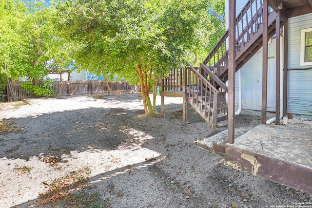 view of yard with a fenced backyard and stairs