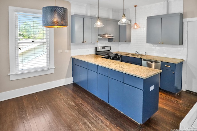 kitchen with under cabinet range hood, a peninsula, appliances with stainless steel finishes, blue cabinetry, and pendant lighting