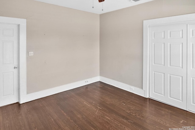 unfurnished room with dark wood-style floors, visible vents, ceiling fan, and baseboards