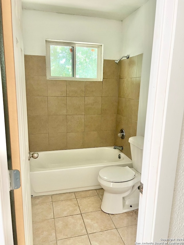 bathroom with tiled shower / bath, toilet, and tile patterned flooring