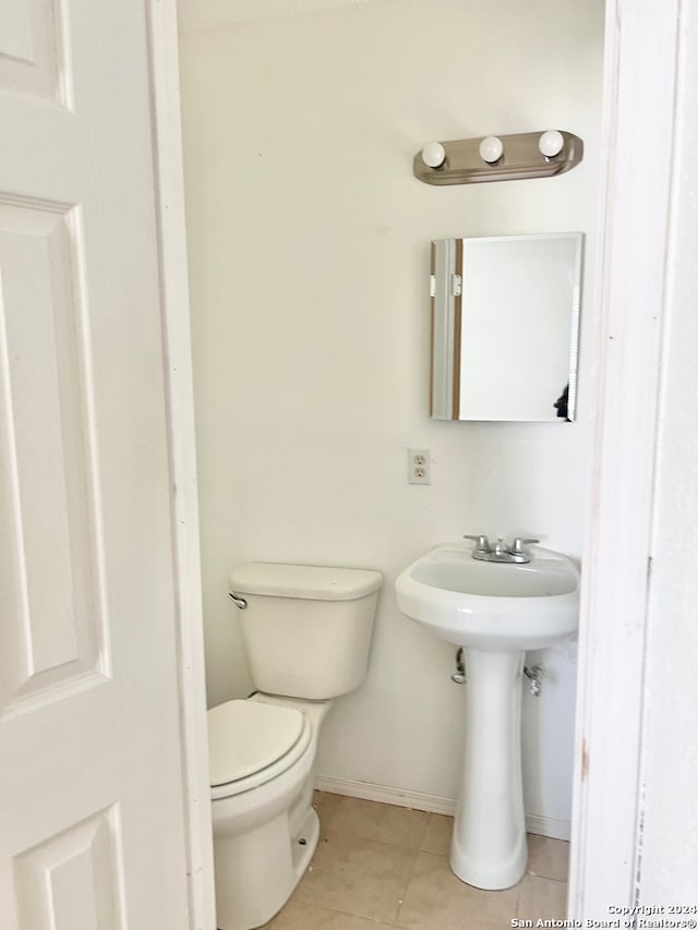 bathroom featuring toilet and tile patterned flooring