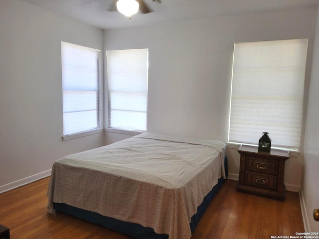 bedroom with ceiling fan and dark hardwood / wood-style flooring