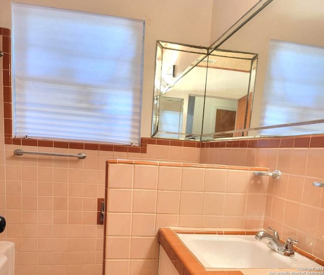 bathroom featuring vanity and tile walls