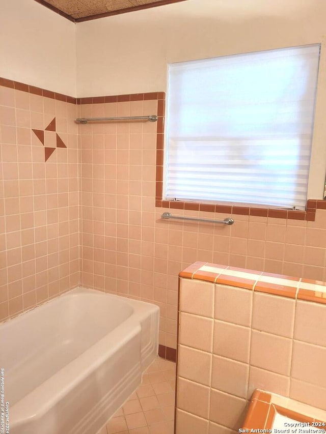 bathroom featuring tiled shower / bath, tile patterned flooring, and tile walls