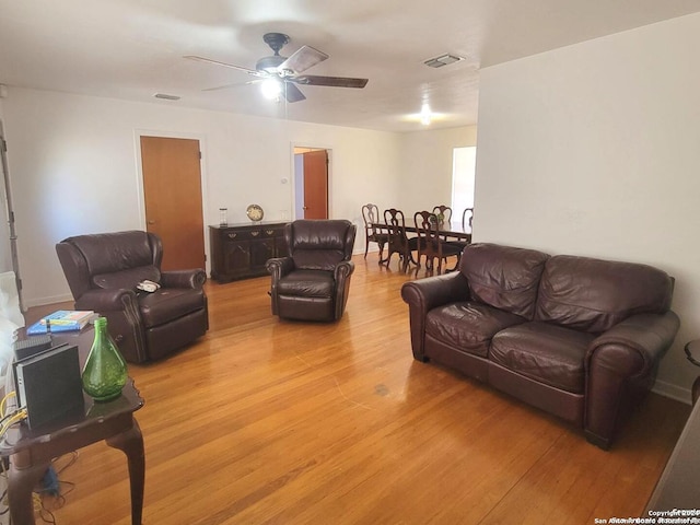 living room featuring light hardwood / wood-style floors and ceiling fan