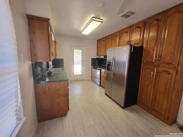 kitchen with stainless steel fridge with ice dispenser, sink, and range