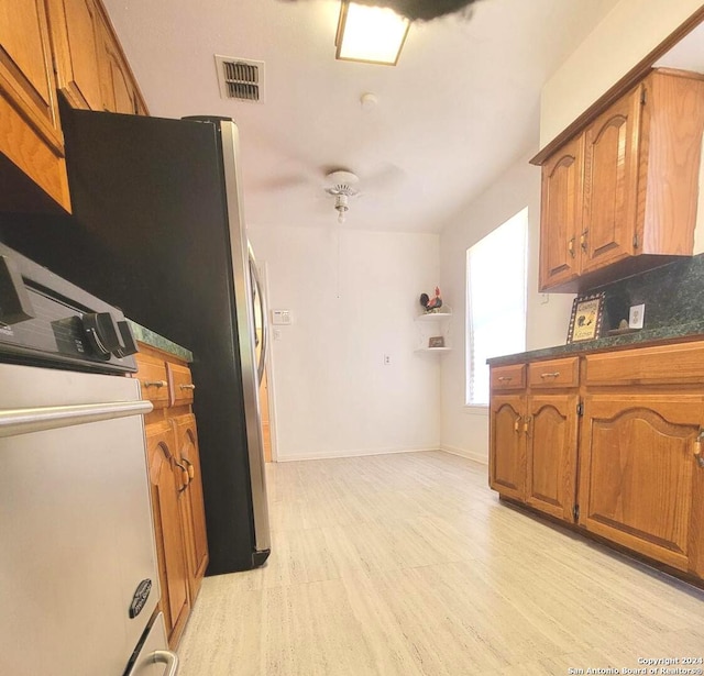 kitchen with light wood-type flooring and stainless steel refrigerator