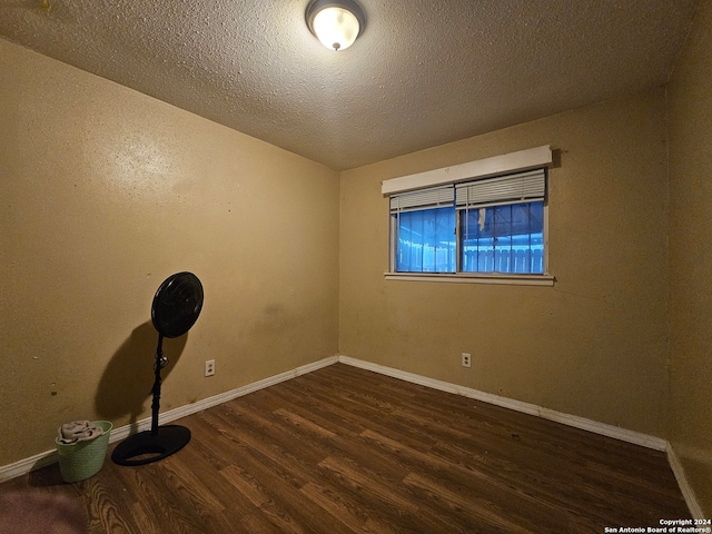 unfurnished room featuring hardwood / wood-style flooring and a textured ceiling