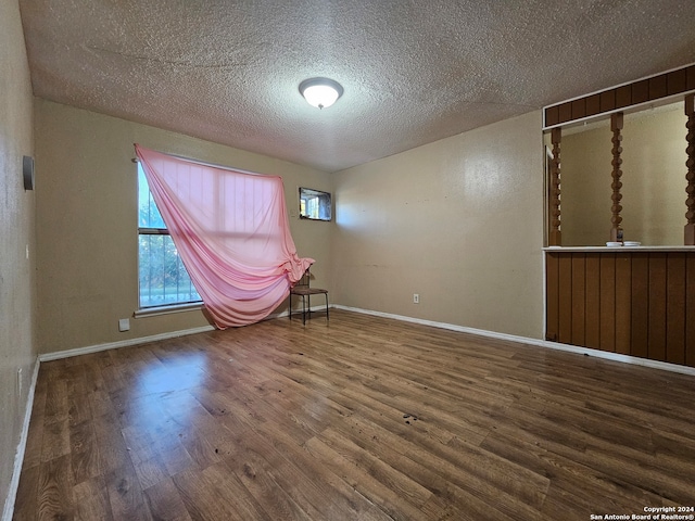 spare room with wood-type flooring and a textured ceiling