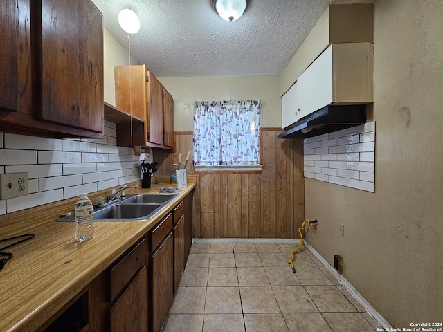 kitchen featuring light tile patterned flooring, sink, decorative backsplash, and a textured ceiling