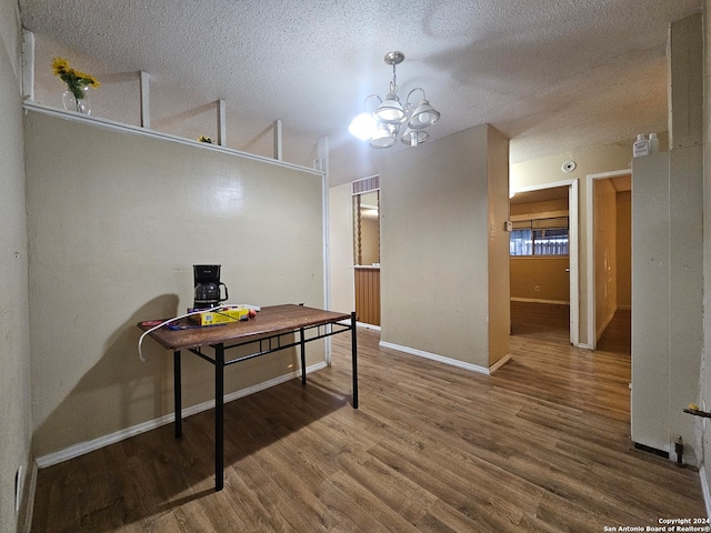 home office featuring hardwood / wood-style floors, an inviting chandelier, and a textured ceiling